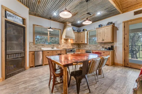 a dining table with chairs and kitchen view