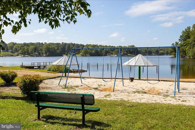 a view of a lake with couches and wooden fence