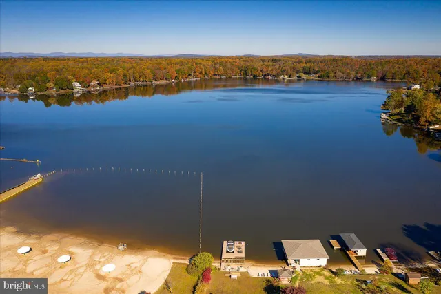 an aerial view of ocean and residential houses with outdoor space