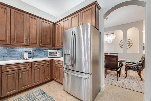 a kitchen with granite countertop a refrigerator stove and microwave