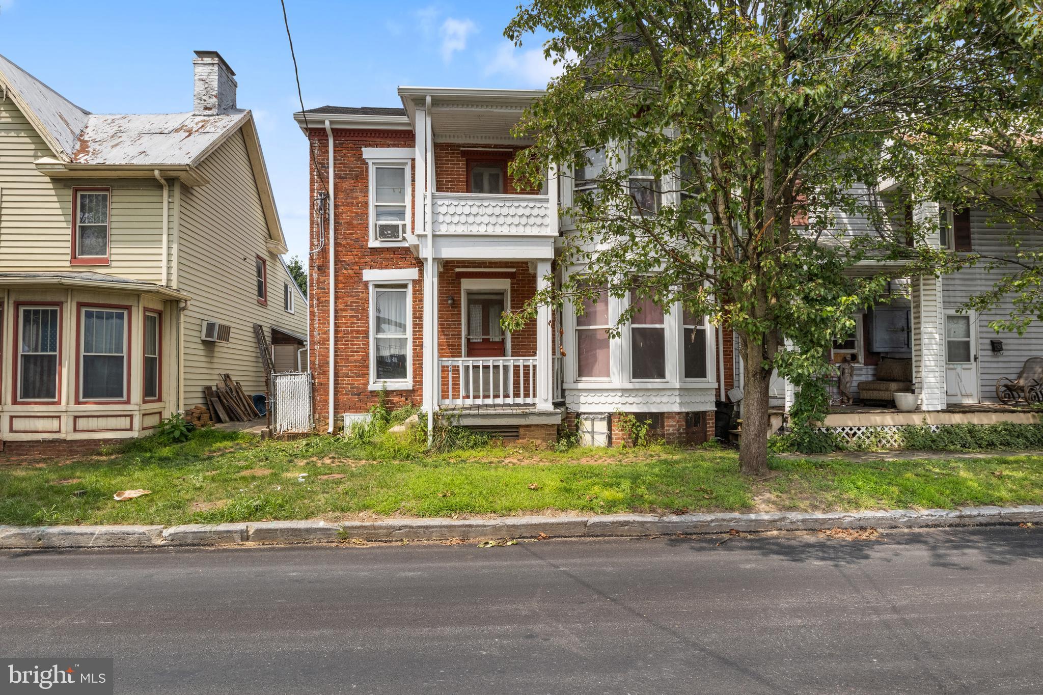 a front view of a house with a garden and trees