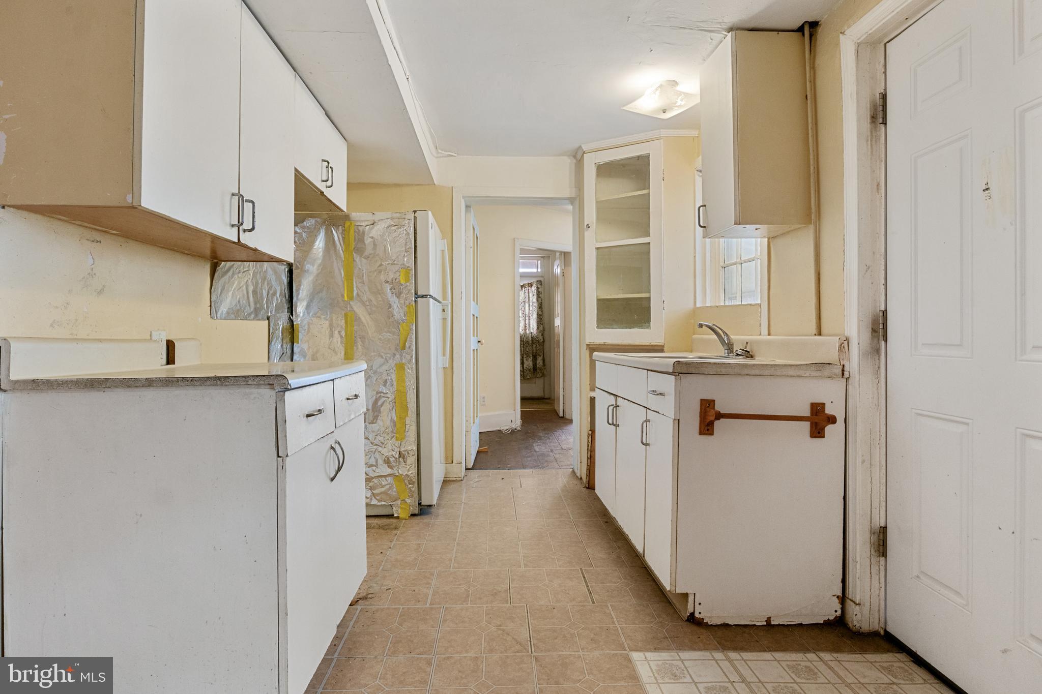 216 Main Street New Windsor, MD 21776 - Photo 6 of 16 a kitchen with a refrigerator a sink and wooden floor