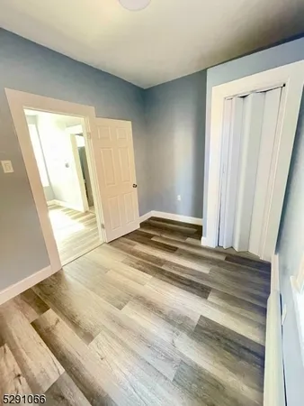 a view of a room with wooden floor and door