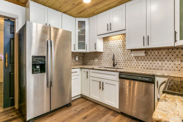 a kitchen with stainless steel appliances granite countertop a refrigerator sink and cabinets