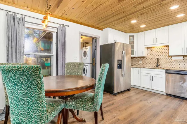 a kitchen with stainless steel appliances granite countertop a refrigerator a stove a sink dishwasher with a dining table and chairs