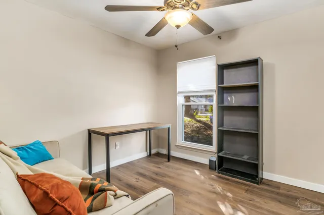 a living room with furniture a ceiling fan and a window