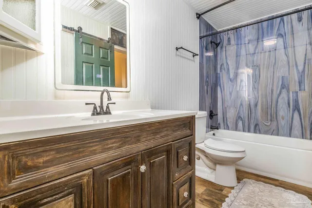 a bathroom with a sink a toilet a mirror and shower