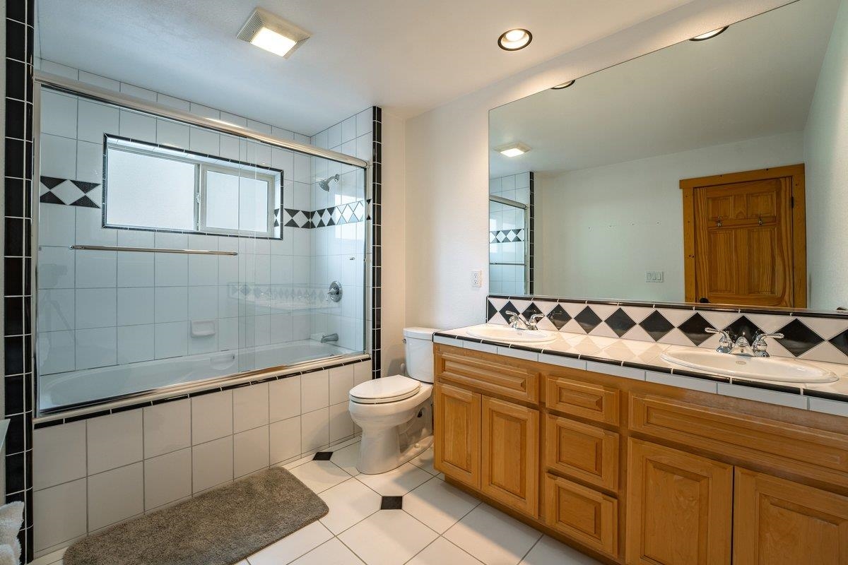 12391 Stockholm Way Truckee, CA 96161 - Photo 26 of 28 a bathroom with a double vanity sink toilet mirror and shower