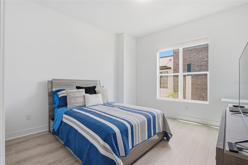 4810 West McElroy Avenue, Unit 30 Tampa, FL 33611 - Photo 29 of 43 a bedroom with a bed a mirror and a window