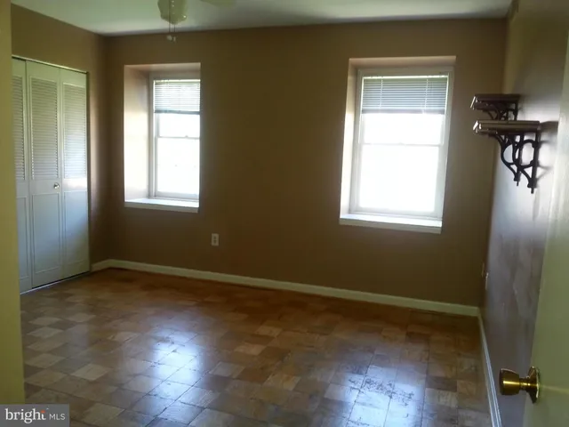 an empty room with a window and wooden floor