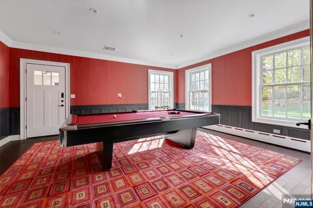 a room with pool table and windows