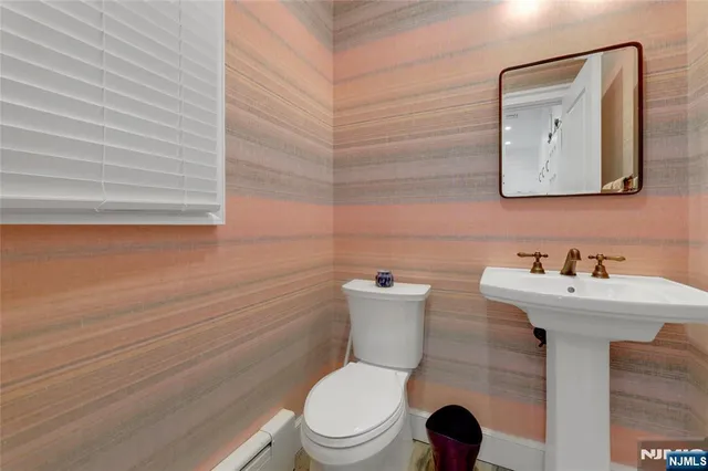 a bathroom with a toilet a sink and mirror