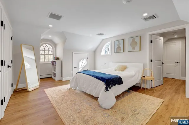 a bedroom with a large bed and a wooden floor