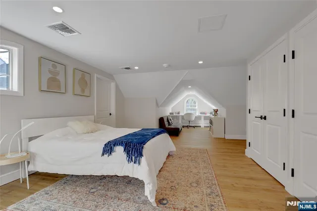 a spacious bedroom with a large bed and a chandelier