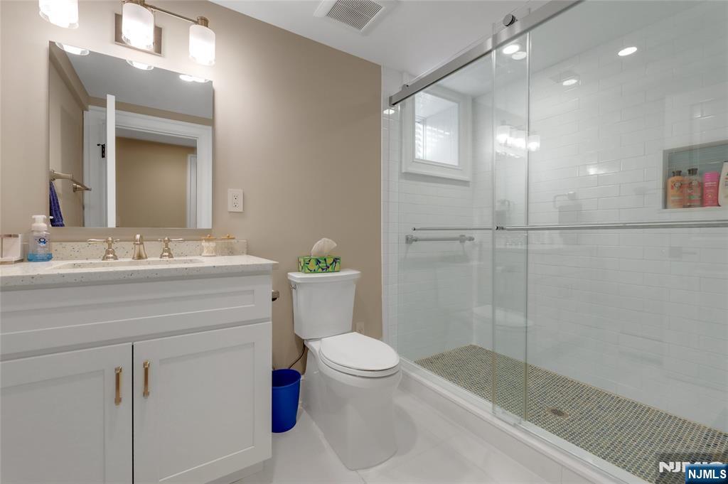 292 Maple Street Englewood, NJ 07631 - Photo 38 of 48 a bathroom with a sink a toilet a mirror and shower