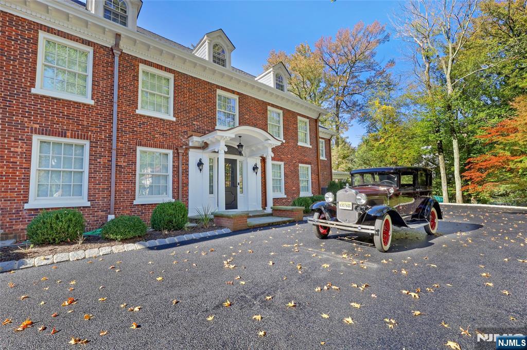 292 Maple Street Englewood, NJ 07631 - Photo 48 of 48 a view of a brick house with many windows and a table and chairs under an umbrella