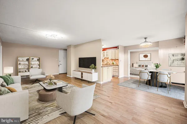 a living room with furniture a flat screen tv and kitchen view
