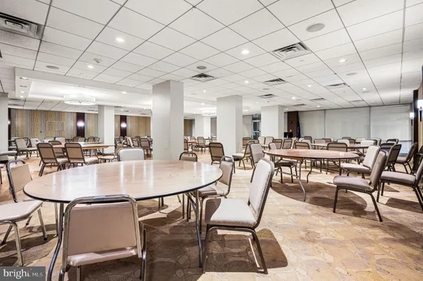 a dining room with lots of tables a chairs and kitchen view