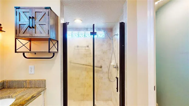 a bathroom with a glass shower door and mirror