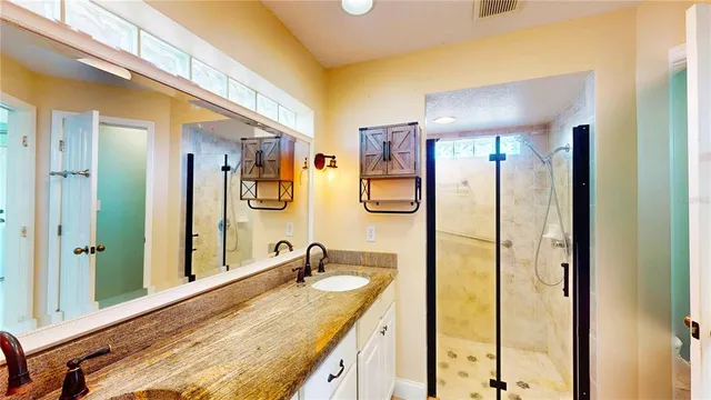 a bathroom with a granite countertop sink and a mirror