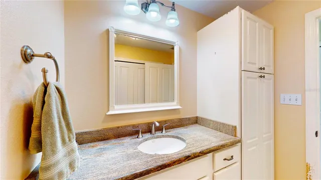 a bathroom with a granite countertop sink and a mirror