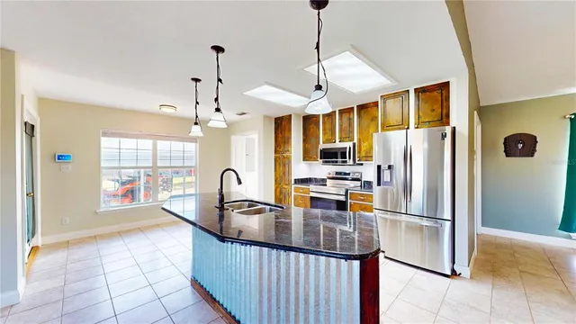 a kitchen with stainless steel appliances granite countertop a refrigerator a stove and a sink with granite countertops
