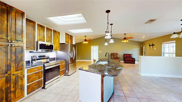 a kitchen with stainless steel appliances granite countertop a sink stove and refrigerator