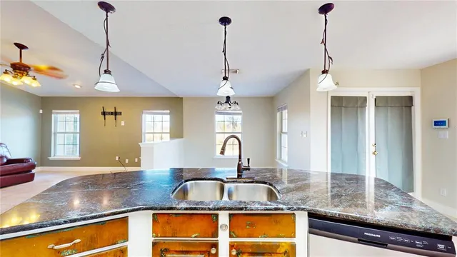 a kitchen with granite countertop a sink and a window