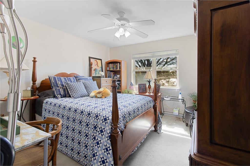 4988 Thunder Road Dallas, TX 75244 - Photo 22 of 31 a bedroom with a large bed and a chandelier