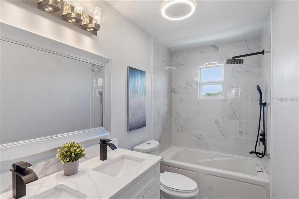 307 161st Avenue Redington Beach, FL 33708 - Photo 13 of 39 a bathroom with a tub shower sink and toilet