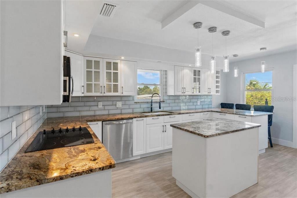 307 161st Avenue Redington Beach, FL 33708 - Photo 29 of 39 a kitchen with stainless steel appliances granite countertop a sink stove and cabinets