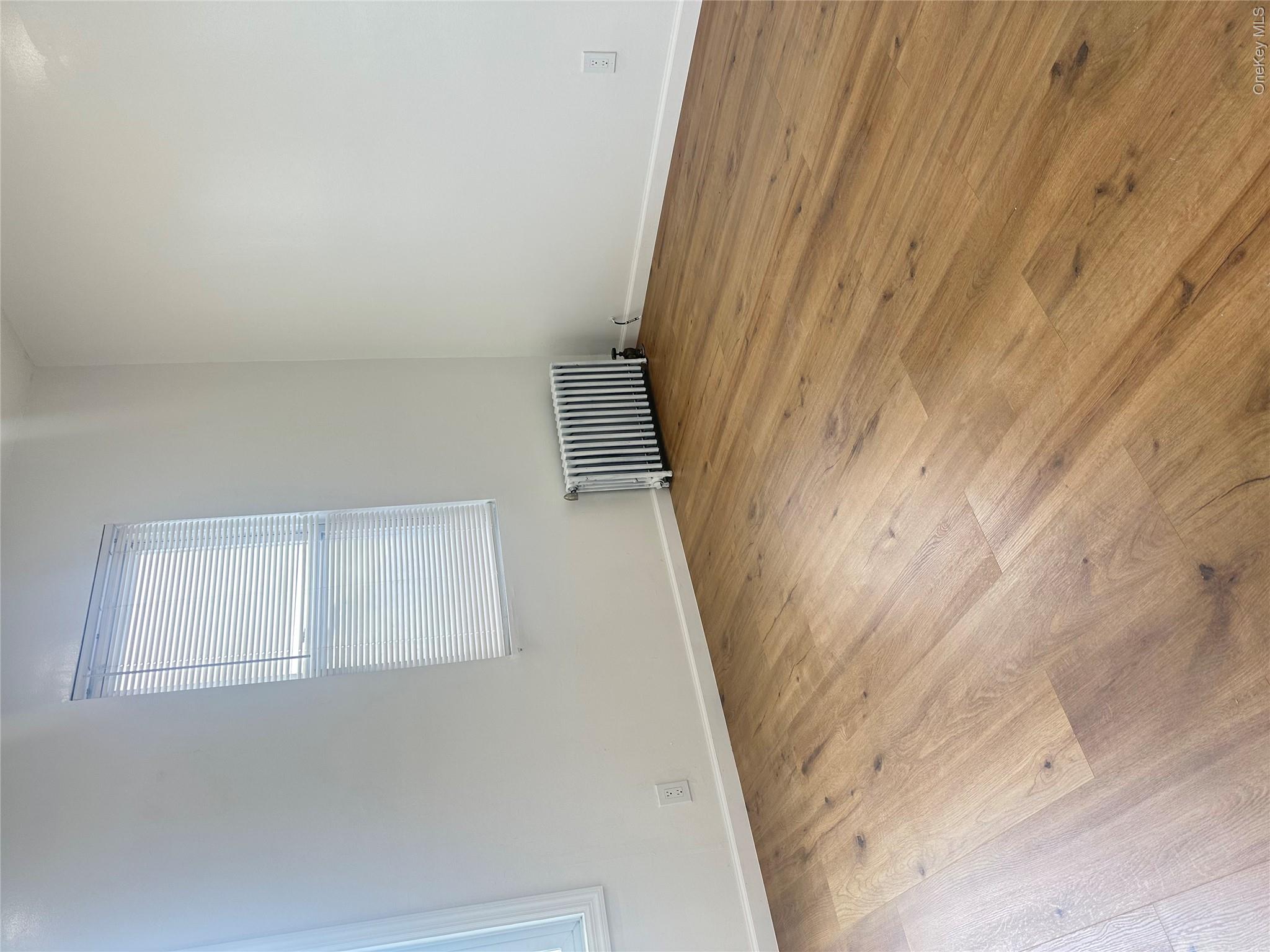 108-69 50th Avenue Queens, NY 11368 - Photo 3 of 10 an empty room with wooden floor and windows