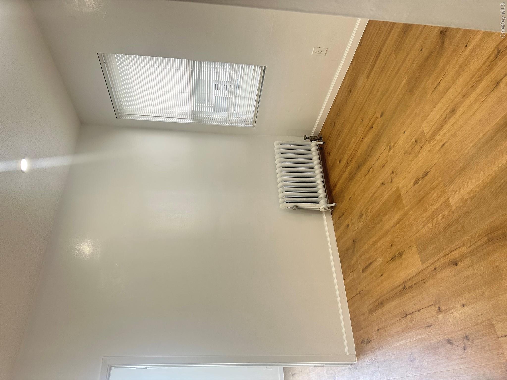 108-69 50th Avenue Queens, NY 11368 - Photo 6 of 10 an empty room with wooden floor and windows