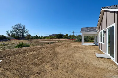 a view of a house with backyard and trees