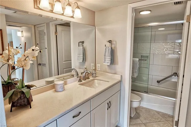 a bathroom with a granite countertop sink a toilet and a mirror