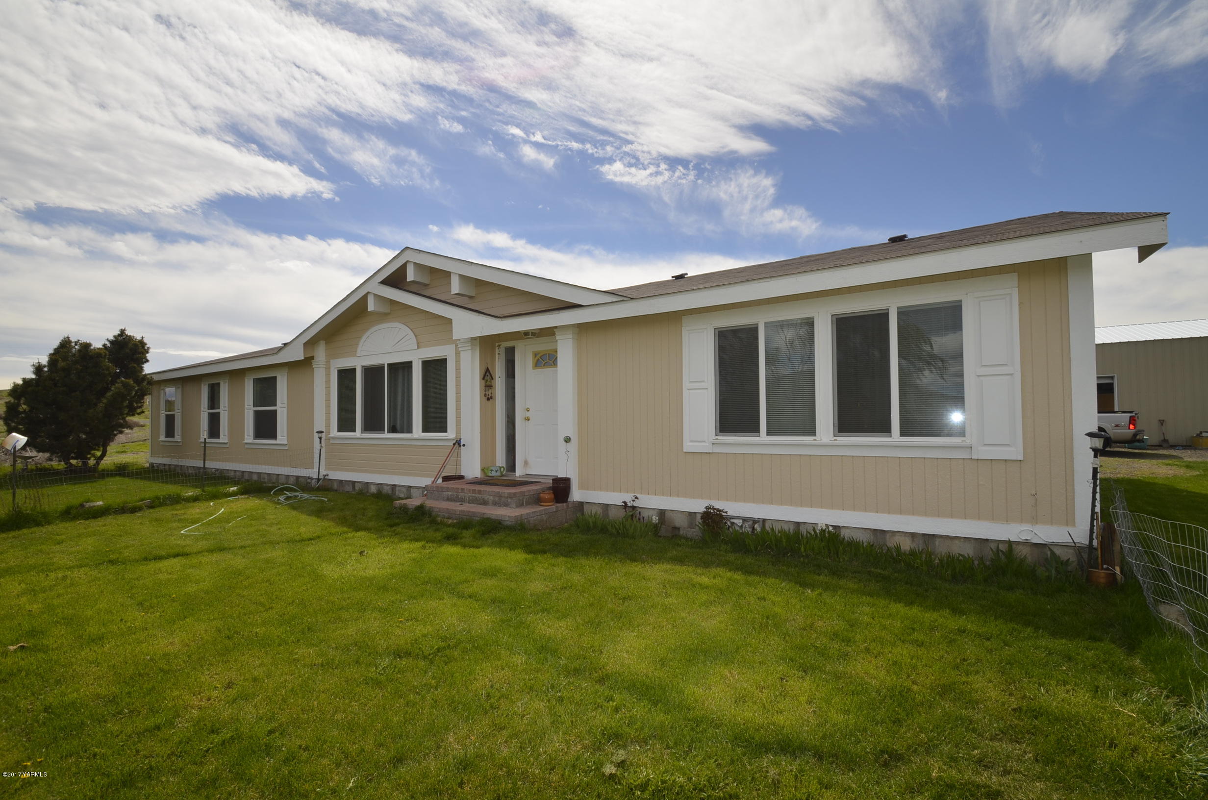 1454 Konnowac Pass Road Moxee, WA 98936 - Photo 1 of 34 a front view of a house with a garden