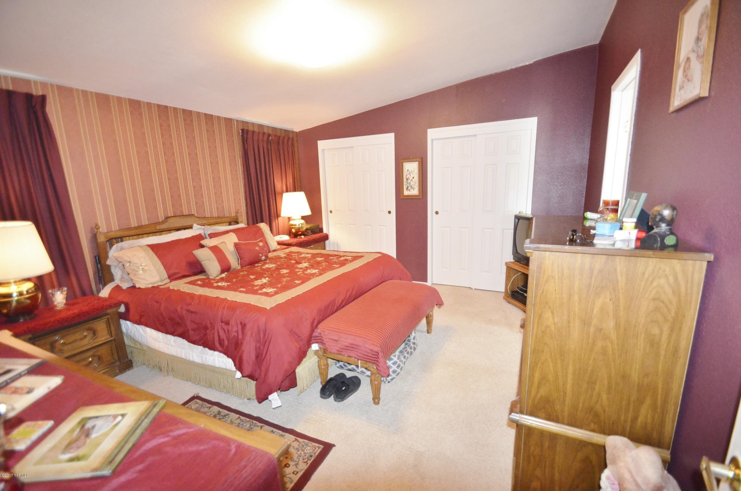 1454 Konnowac Pass Road Moxee, WA 98936 - Photo 14 of 34 a bedroom with a bed and a dresser next to a window