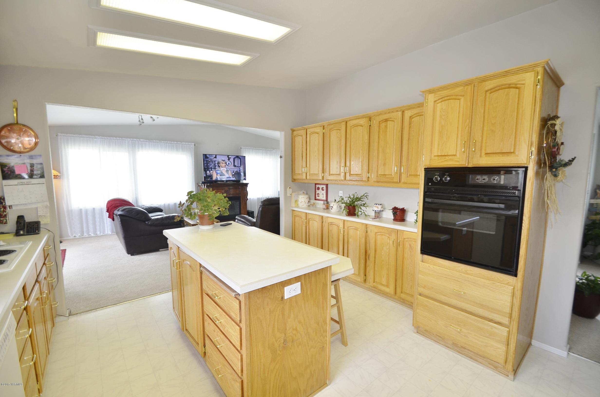 1454 Konnowac Pass Road Moxee, WA 98936 - Photo 30 of 34 a kitchen with a sink a stove top oven a refrigerator cabinets and a dining table