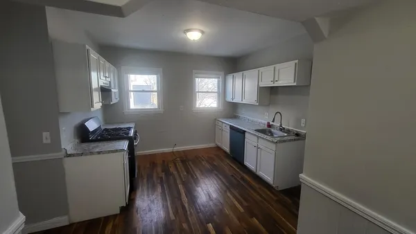 a kitchen with wooden floors and appliances