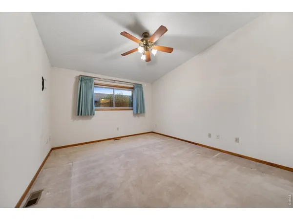 a view of a room with a ceiling fan and window