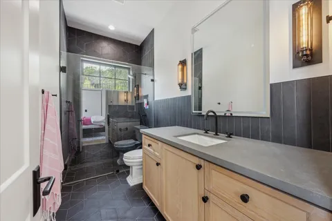 a bathroom with a granite countertop sink a mirror and a toilet