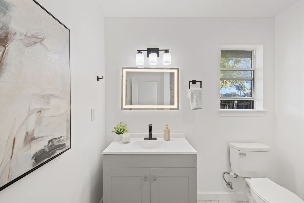 902 Virginia Drive Round Rock, TX 78664 - Photo 18 of 33 a bathroom with a toilet a sink and mirror
