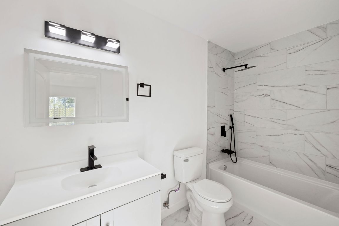 902 Virginia Drive Round Rock, TX 78664 - Photo 26 of 33 a bathroom with a sink a toilet and a mirror