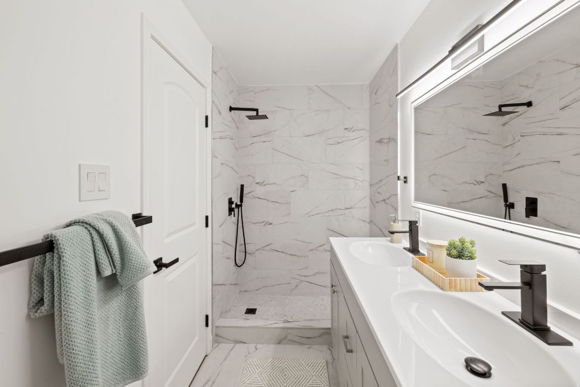 902 Virginia Drive Round Rock, TX 78664 - Photo 28 of 33 a bathroom with a tub sink and mirror