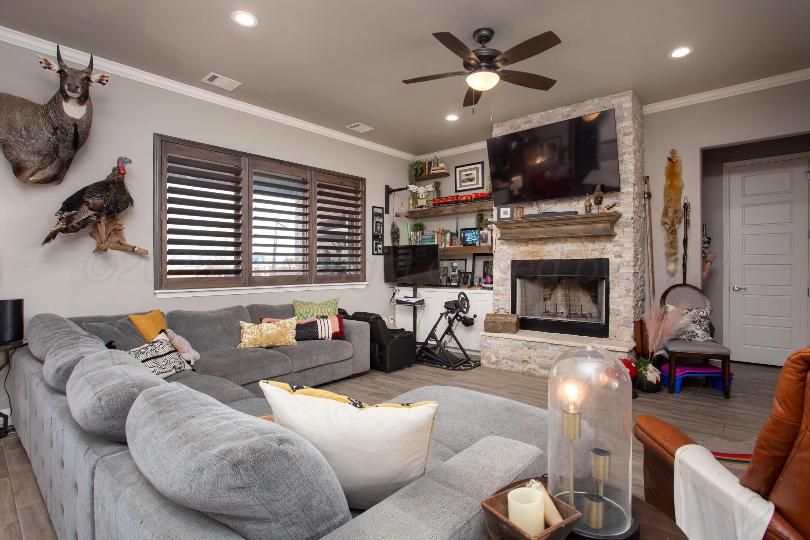 8200 Matilda Lane Amarillo, TX 79119 - Photo 6 of 39 a living room with furniture a fireplace and a flat screen tv