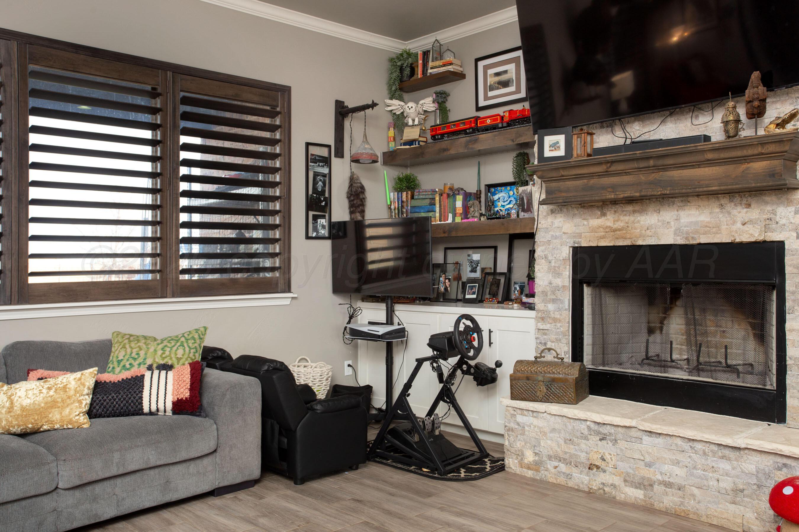 8200 Matilda Lane Amarillo, TX 79119 - Photo 7 of 39 a living room with furniture a flat screen tv and a fireplace