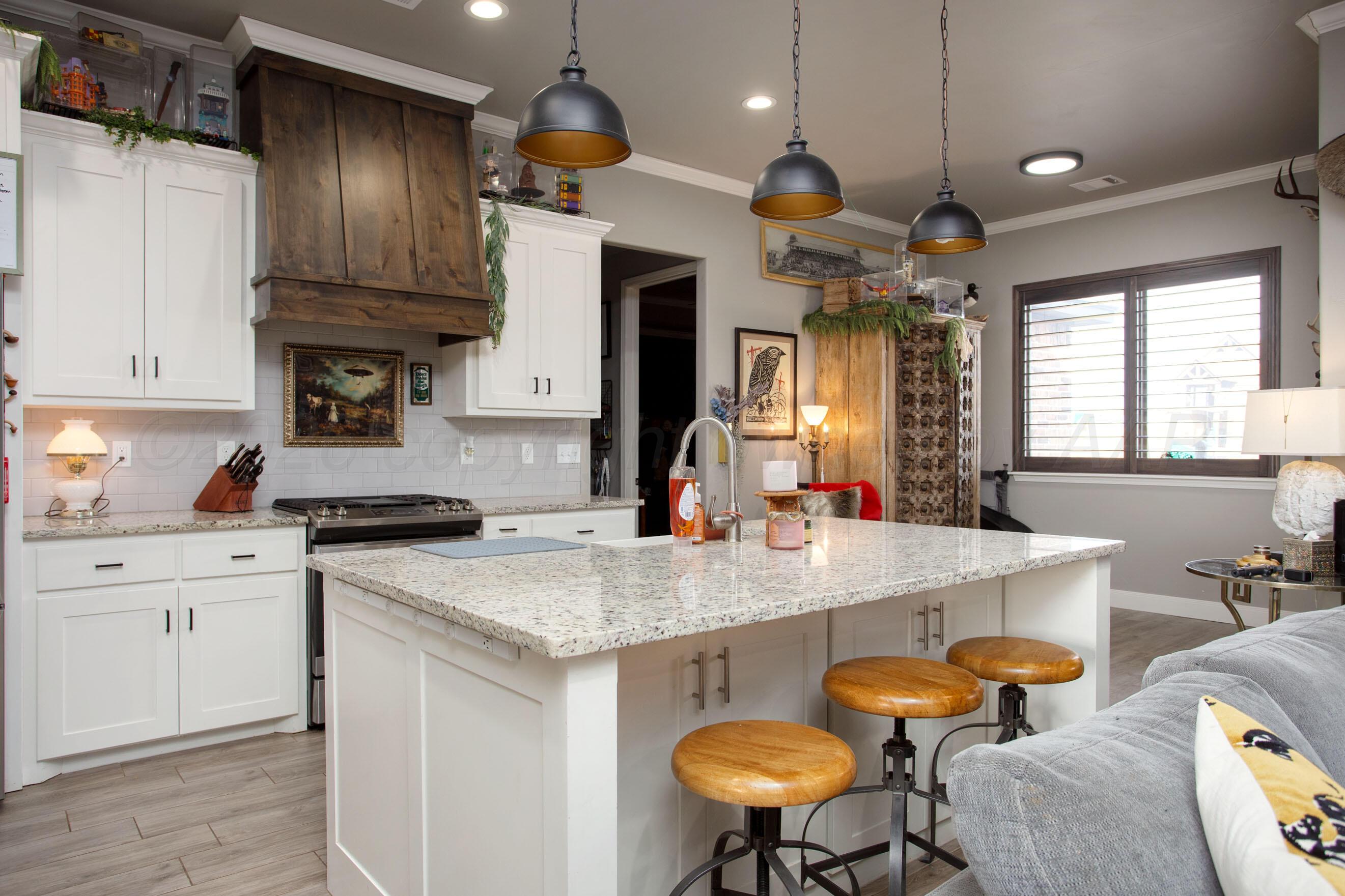 8200 Matilda Lane Amarillo, TX 79119 - Photo 8 of 39 a kitchen with a sink a stove and chairs