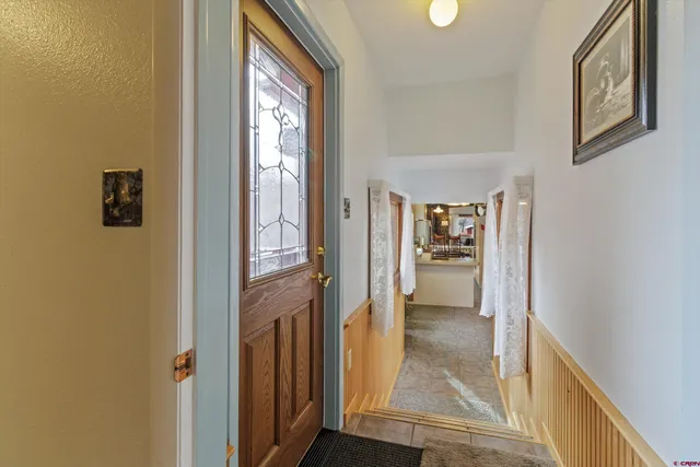 a view of a hallway with wooden floor and a dining room