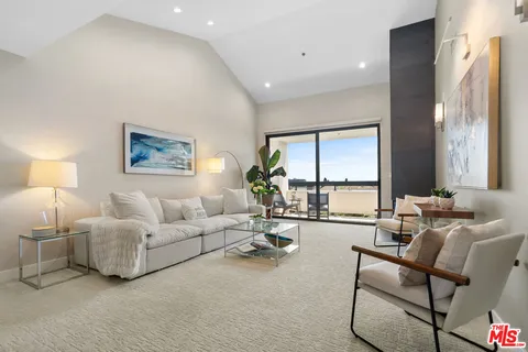 a living room with furniture large window and a flat screen tv