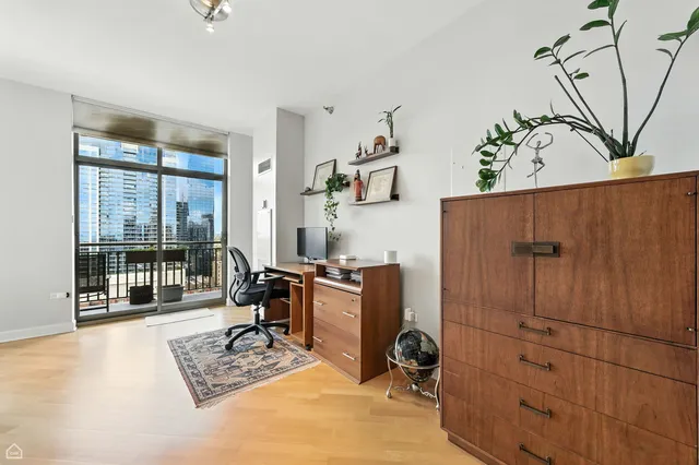 a view of a workspace with furniture and a window